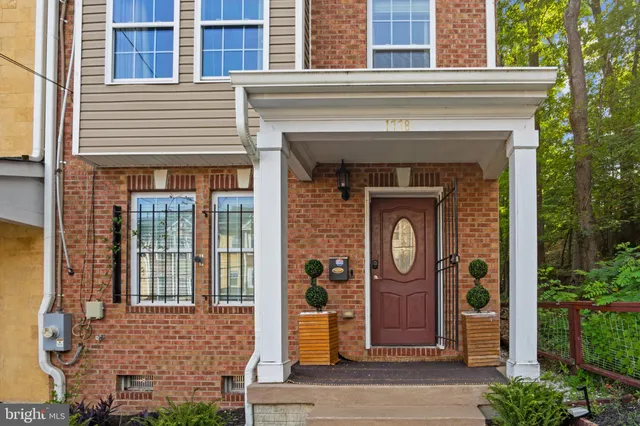 a front view of a house with a potted plant and a large window