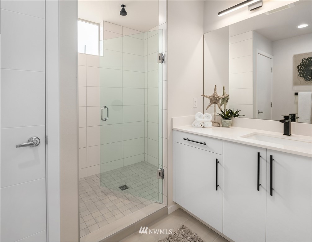 8370 Loyal Way Northwest, Unit B Seattle, WA 98117 - Photo 12 of 19 a bathroom with a shower sink and mirror