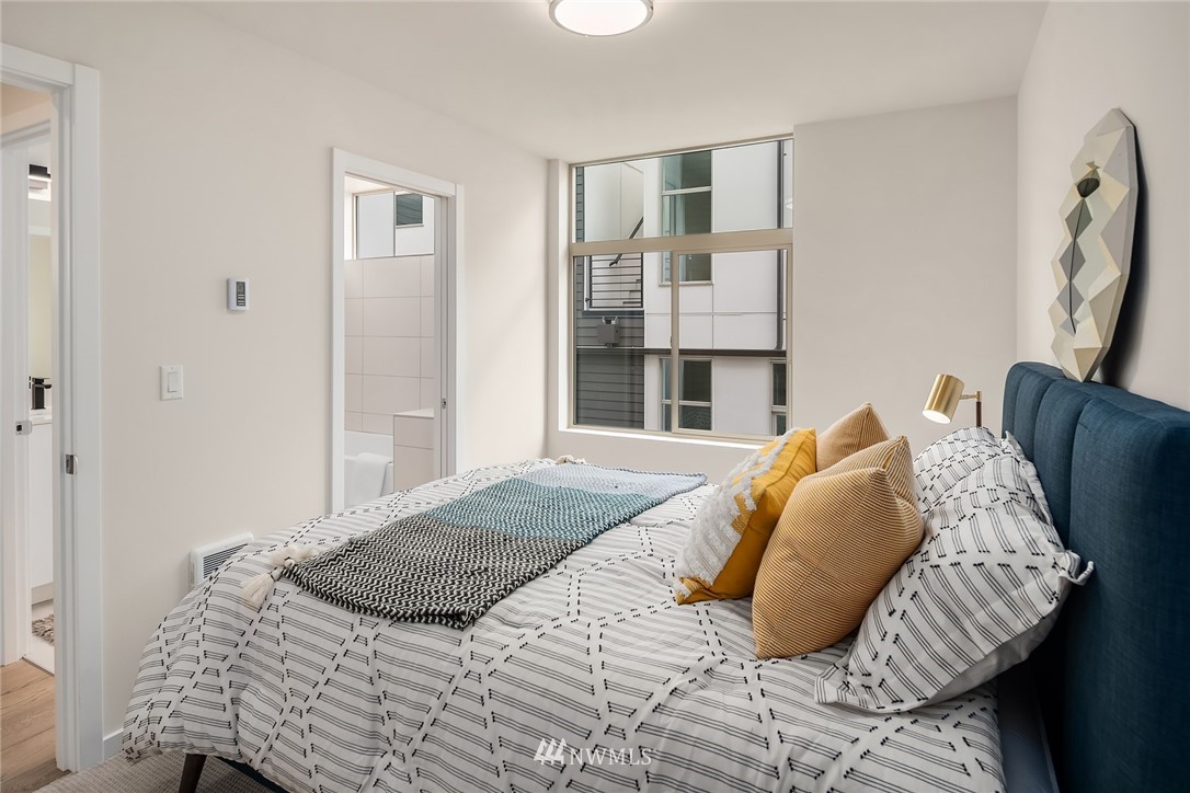 8370 Loyal Way Northwest, Unit B Seattle, WA 98117 - Photo 14 of 19 a bedroom with a bed and a window