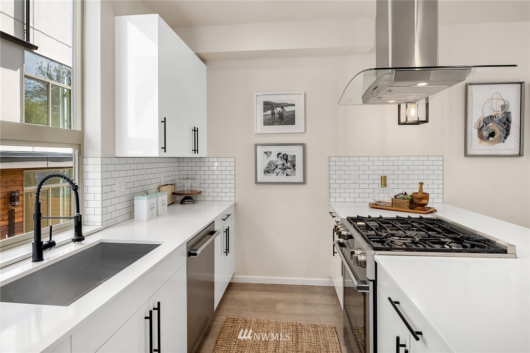 8370 Loyal Way Northwest, Unit B Seattle, WA 98117 - Photo 3 of 19 a kitchen with stainless steel appliances a stove a sink and a refrigerator