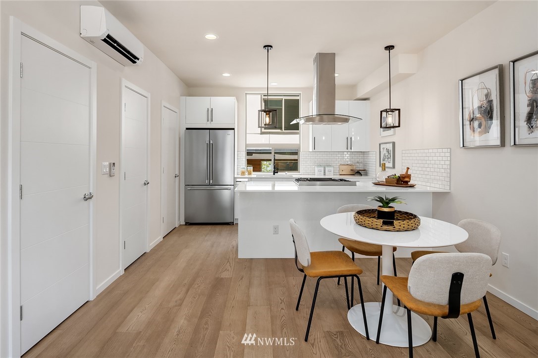 8370 Loyal Way Northwest, Unit B Seattle, WA 98117 - Photo 5 of 19 a kitchen with stainless steel appliances kitchen island granite countertop a dining table chairs and a refrigerator