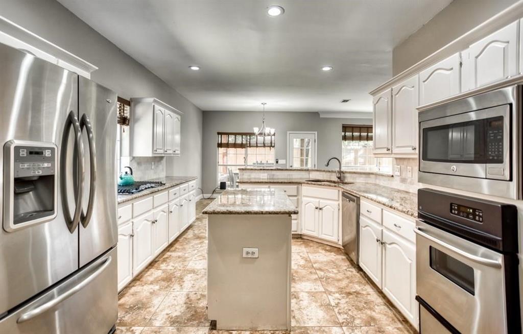 5421 North Briar Ridge Circle McKinney, TX 75072 - Photo 12 of 27 Kitchen with appliances with stainless steel finishes, a chandelier, a peninsula, light stone counters, and recessed lighting