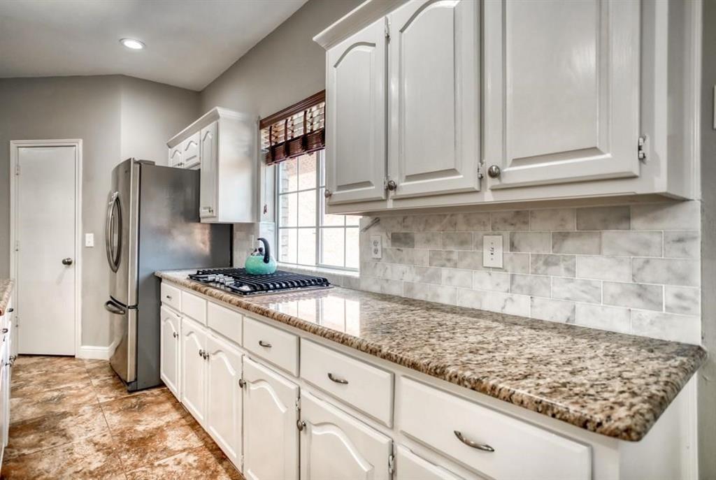 5421 North Briar Ridge Circle McKinney, TX 75072 - Photo 13 of 27 Kitchen featuring white cabinetry, light stone countertops, stainless steel appliances, decorative backsplash, and recessed lighting