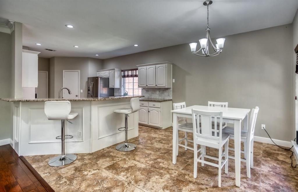5421 North Briar Ridge Circle McKinney, TX 75072 - Photo 14 of 27 Kitchen with a breakfast bar, hanging light fixtures, a peninsula, decorative backsplash, and recessed lighting