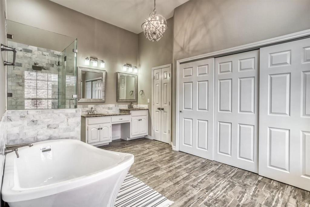 5421 North Briar Ridge Circle McKinney, TX 75072 - Photo 18 of 27 Full bath with a freestanding tub, double vanity, a shower stall, a chandelier, and tile walls