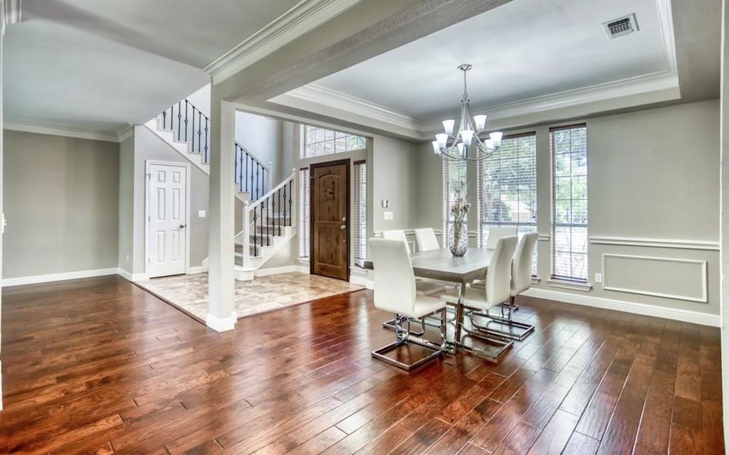 5421 North Briar Ridge Circle McKinney, TX 75072 - Photo 2 of 27 Dining area with stairway, ornamental molding, a raised ceiling, dark wood-type flooring, and a chandelier