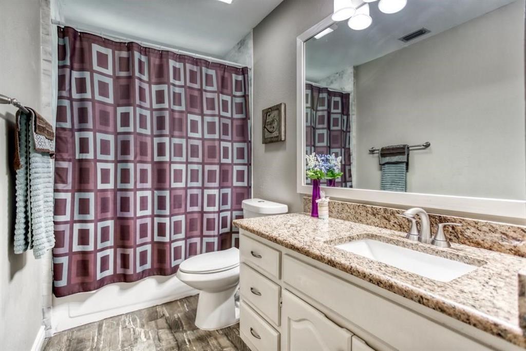5421 North Briar Ridge Circle McKinney, TX 75072 - Photo 23 of 27 Bathroom featuring vanity, dark wood-style floors, and shower / bath combo