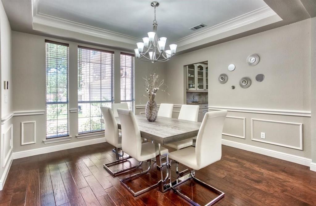 5421 North Briar Ridge Circle McKinney, TX 75072 - Photo 3 of 27 Dining space with a raised ceiling, a decorative wall, ornamental molding, wainscoting, and dark wood finished floors