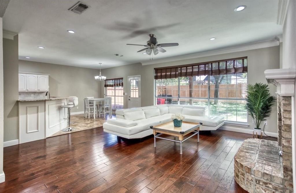 5421 North Briar Ridge Circle McKinney, TX 75072 - Photo 6 of 27 Living area with healthy amount of natural light, crown molding, a ceiling fan, dark wood-style floors, and a chandelier