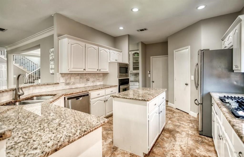 5421 North Briar Ridge Circle McKinney, TX 75072 - Photo 9 of 27 Kitchen with backsplash, a center island, white cabinetry, appliances with stainless steel finishes, and recessed lighting