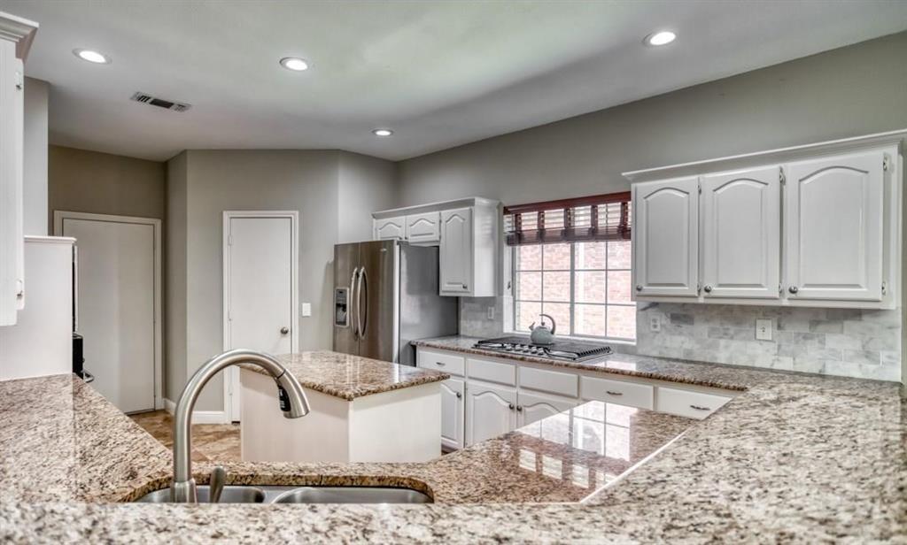 5421 North Briar Ridge Circle McKinney, TX 75072 - Photo 10 of 27 Kitchen with white cabinetry, recessed lighting, light stone countertops, decorative backsplash, and appliances with stainless steel finishes