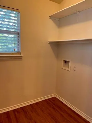 a view of a small space with wooden floor and a window