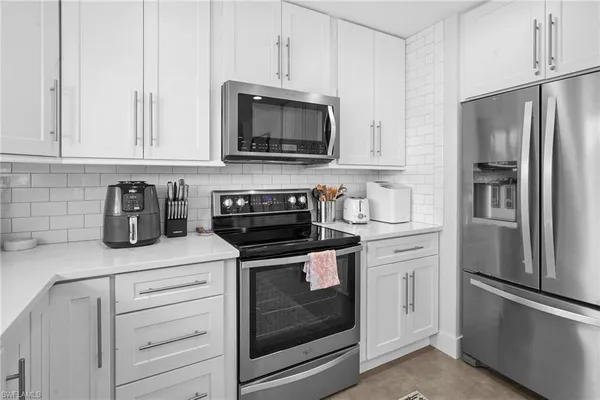 a kitchen with white cabinets and white appliances