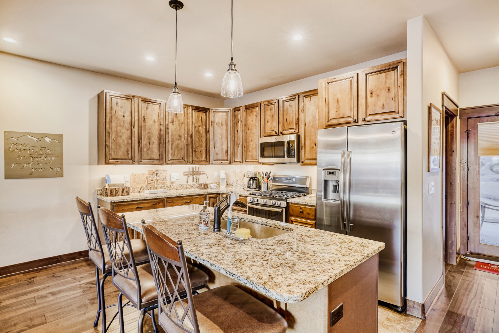 852 Independence Road, Unit B Keystone, CO 80435 - Photo 16 of 38 a kitchen with granite countertop a table chairs stainless steel appliances and wooden floor