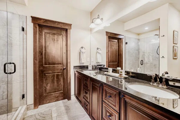 a en suite bathroom with a shower sink and mirror