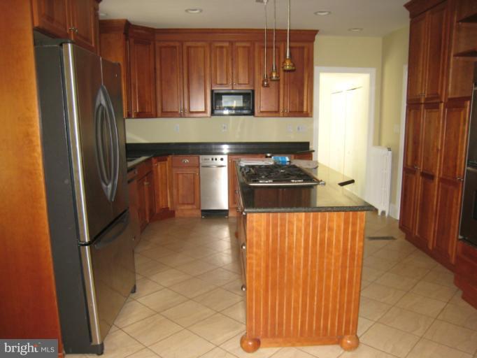 907 Old Oak Road Baltimore, MD 21212 - Photo 12 of 28 a kitchen with granite countertop a refrigerator and a stove