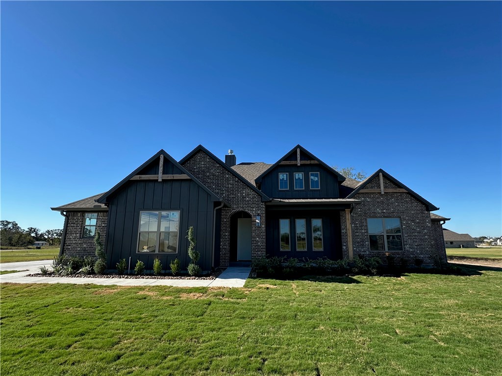10474 Whiskey River Road Bryan, TX 77808 - Photo 1 of 1 Craftsman inspired home featuring a front lawn, board and batten siding, a chimney, and brick siding