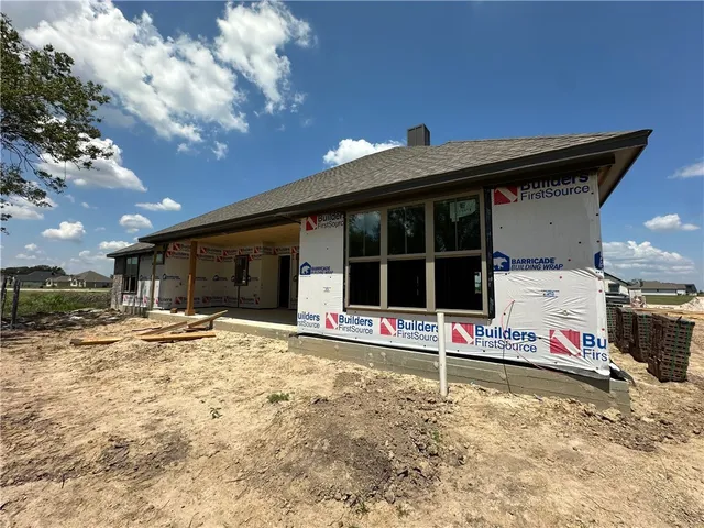 a view of a white house with a flower in a garden