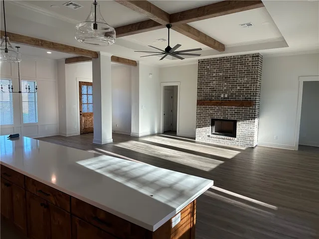 a living room with stainless steel appliances kitchen island granite countertop furniture and fireplace
