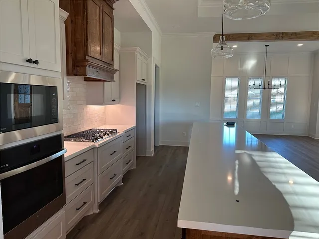 a living room with stainless steel appliances kitchen island granite countertop furniture and a view of bedroom