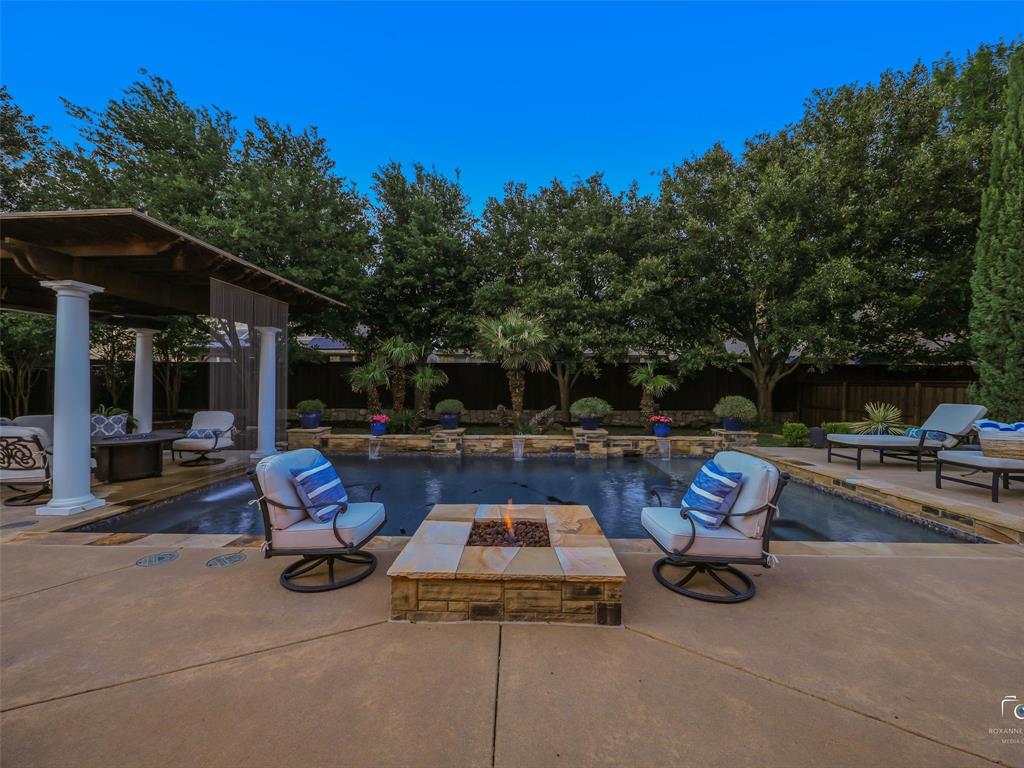 3117 Callander The Colony, TX 75056 - Photo 5 of 40 Resort like backyard with covered pergola, firepit and pool with sundeck and rain curtain. Pergola has built in heater for year around use.