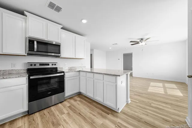 a kitchen with granite countertop a stove and a microwave