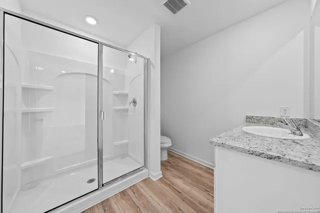 a bathroom with a granite countertop sink mirror and shower
