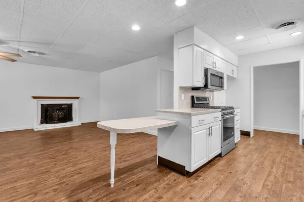 a kitchen with kitchen island a white cabinets and appliances