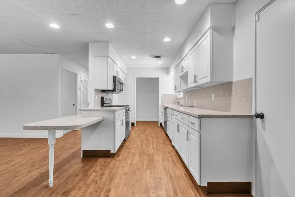a kitchen with white cabinets and white appliances