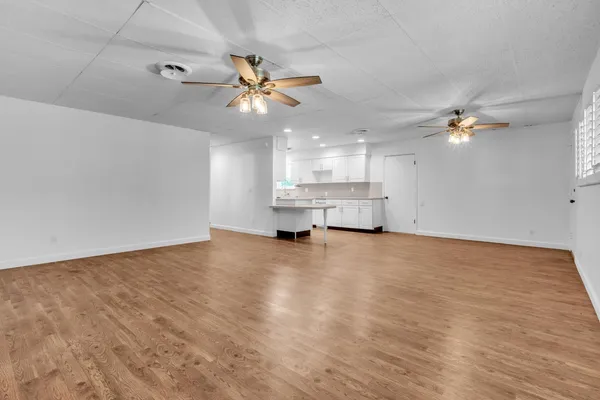 a view of a livingroom with a ceiling fan window and a ceiling fan