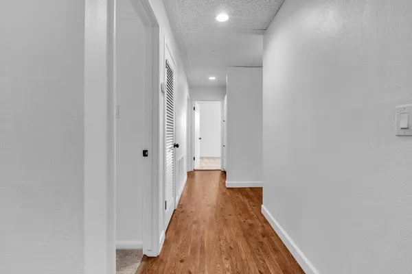 a view of a hallway with wooden floor