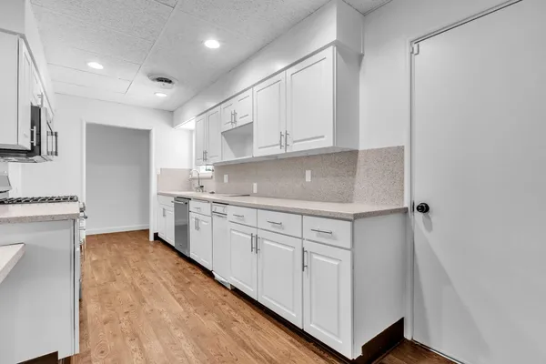 a kitchen with granite countertop white cabinets and white appliances