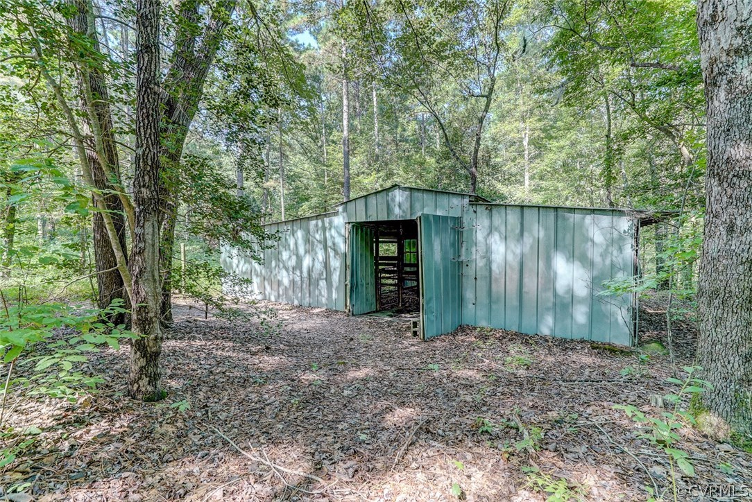 17684 Baltimore Road Dewitt, VA 23840 - Photo 32 of 42 a view of a house with large trees and plants