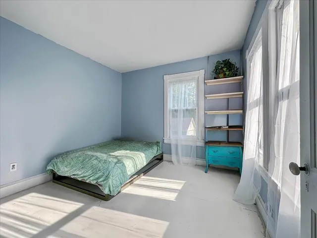 a bedroom with a bed and a window