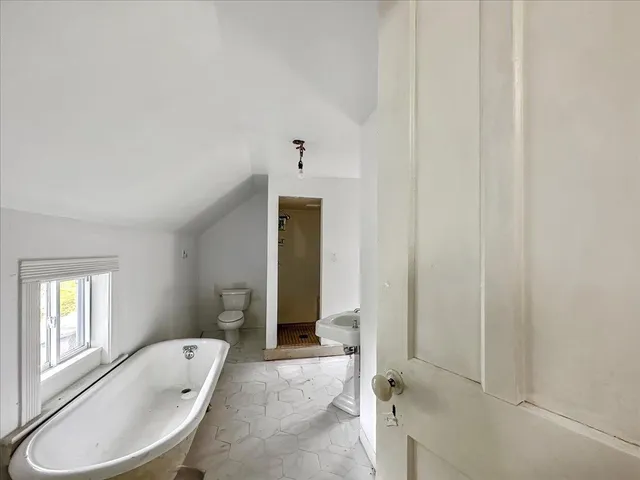 a bathroom with a tub sink shower and mirror