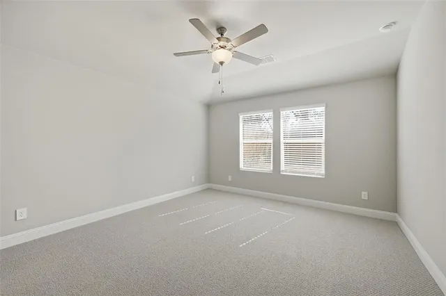 an empty room with a window and a ceiling fan