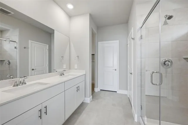 a spacious bathroom with a double vanity sink mirror and shower