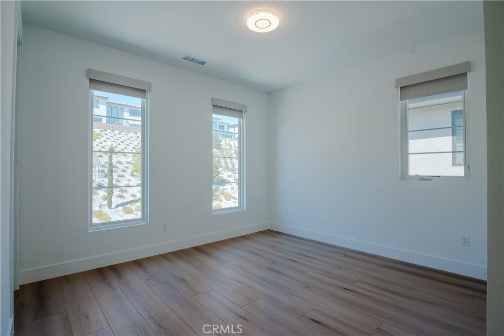 11752 Hillsborough Lane Porter Ranch, CA 91326 - Photo 37 of 45 a view of an empty room with wooden floor and a window