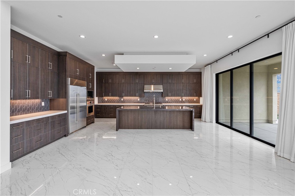 11752 Hillsborough Lane Porter Ranch, CA 91326 - Photo 9 of 45 a large kitchen with a large counter top stainless steel appliances and cabinets
