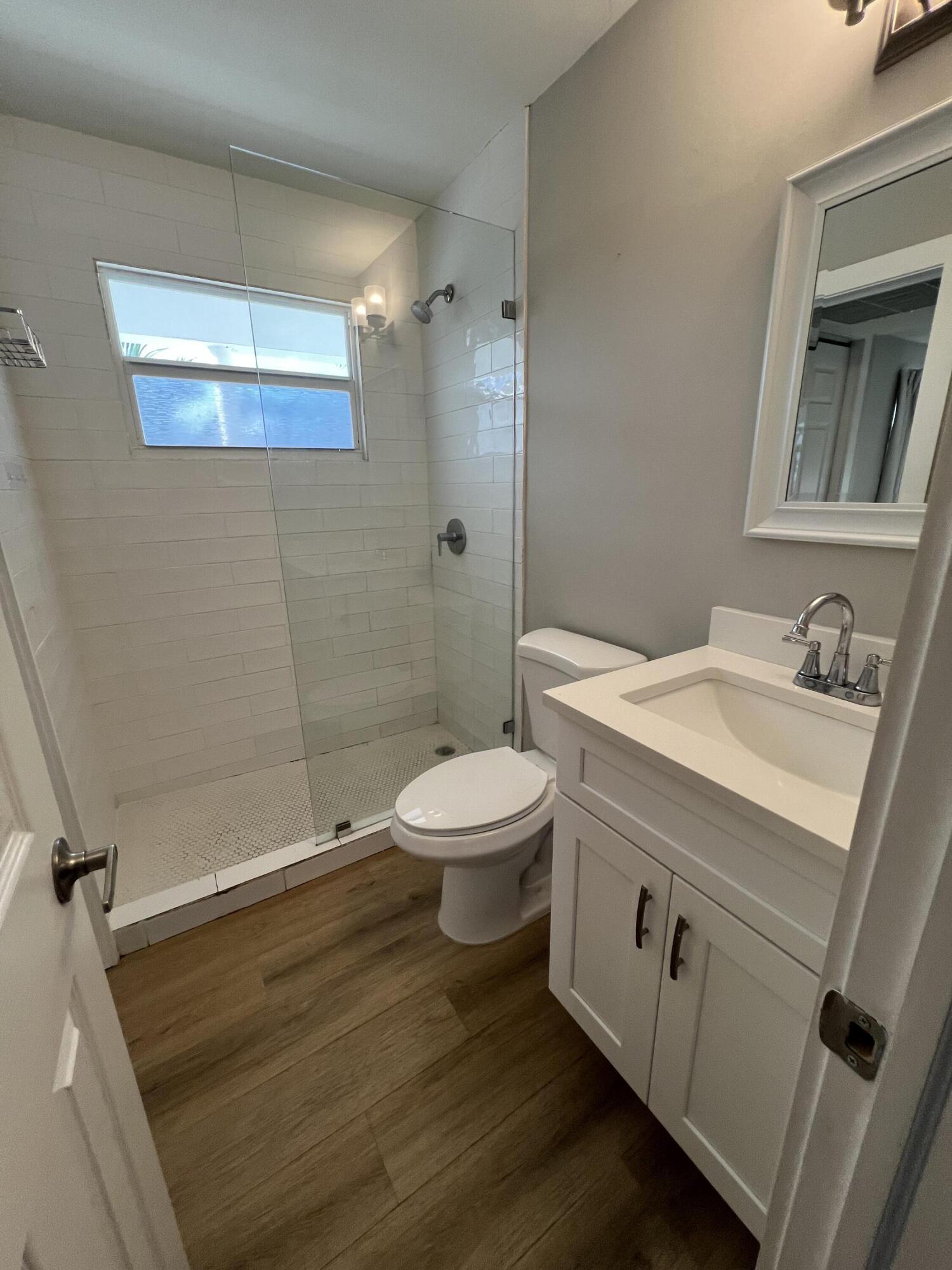 6600 North Ocean Boulevard, Unit 17 Ocean Ridge, FL 33435 - Photo 16 of 21 a bathroom with a granite countertop toilet a sink and a mirror
