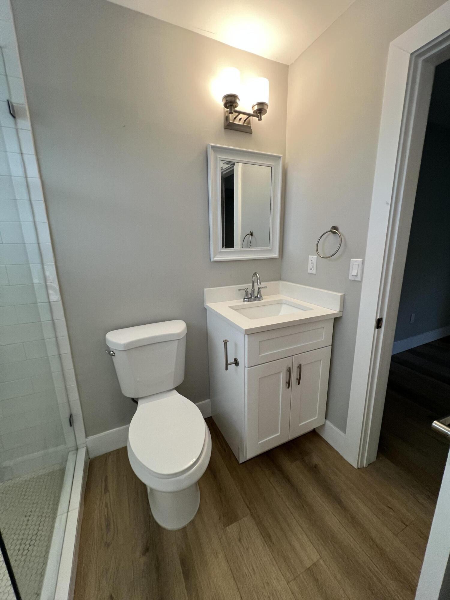 6600 North Ocean Boulevard, Unit 17 Ocean Ridge, FL 33435 - Photo 17 of 21 a bathroom with a toilet a sink and a mirror