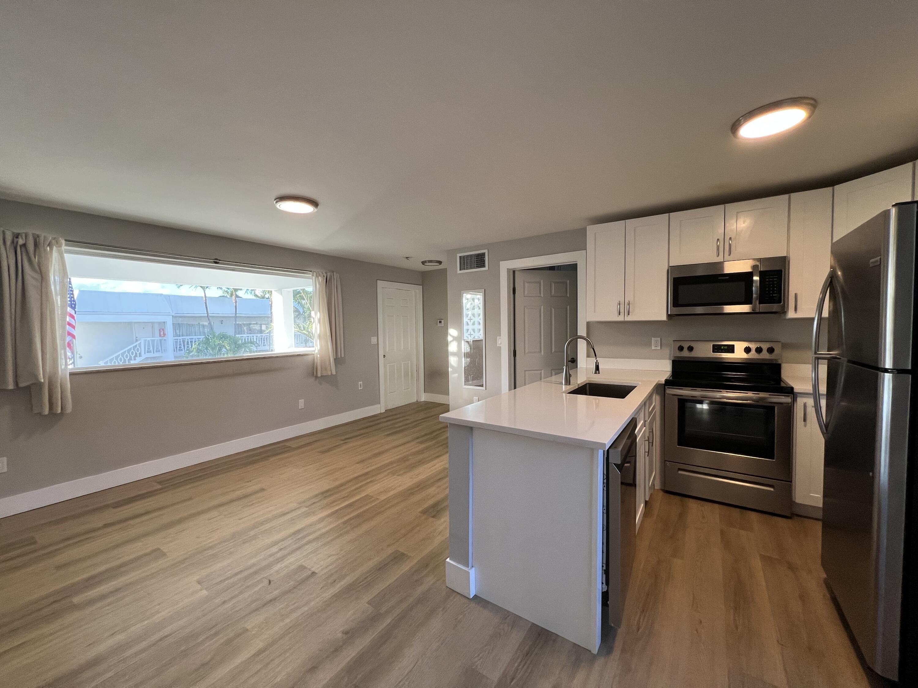 6600 North Ocean Boulevard, Unit 17 Ocean Ridge, FL 33435 - Photo 10 of 21 a kitchen with kitchen island wooden cabinets and stainless steel appliances
