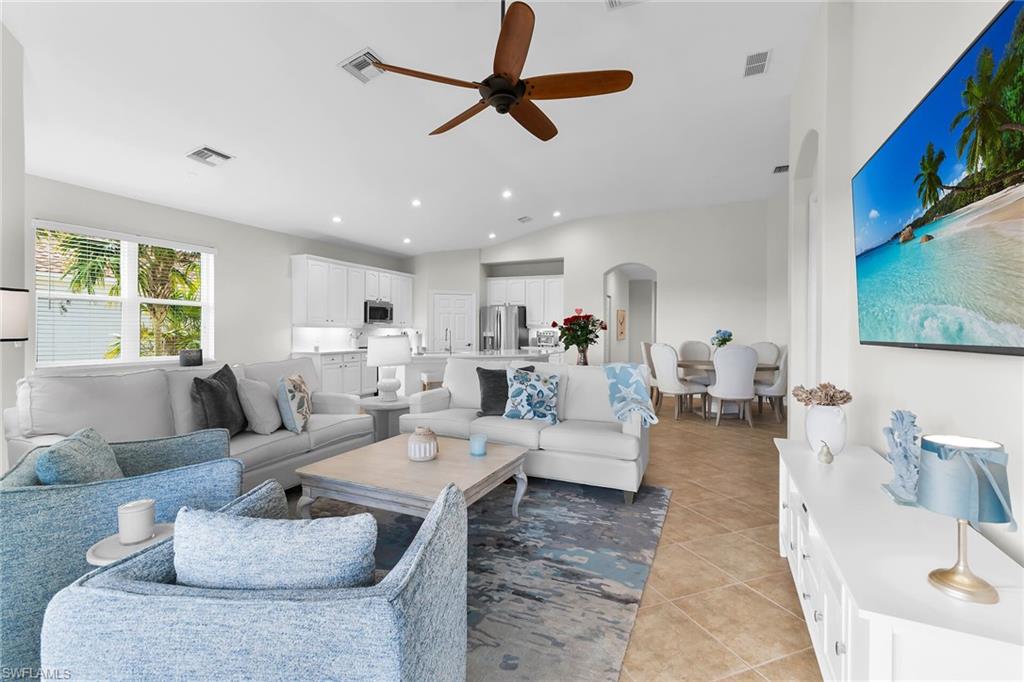 1286 Rialto Way, Unit 9202 Naples, FL 34114 - Photo 14 of 49 Expansive great room with vaulted ceilings, recessed lighting, and open-concept design connecting the living area, dining space, and updated kitchen.