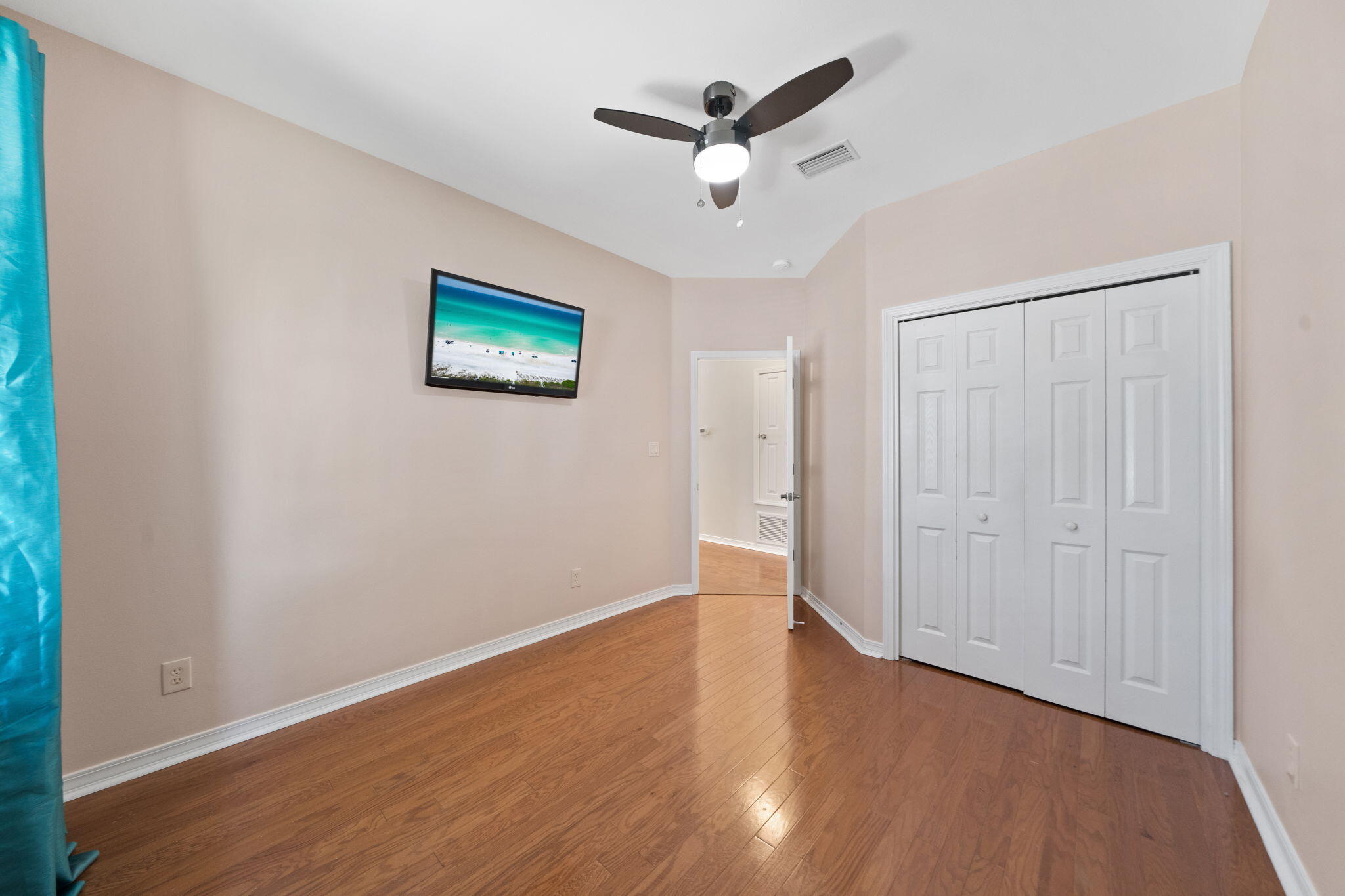 229 Inverrary Drive Destin, FL 32541 - Photo 28 of 35 an empty room with wooden floor and ceiling fan