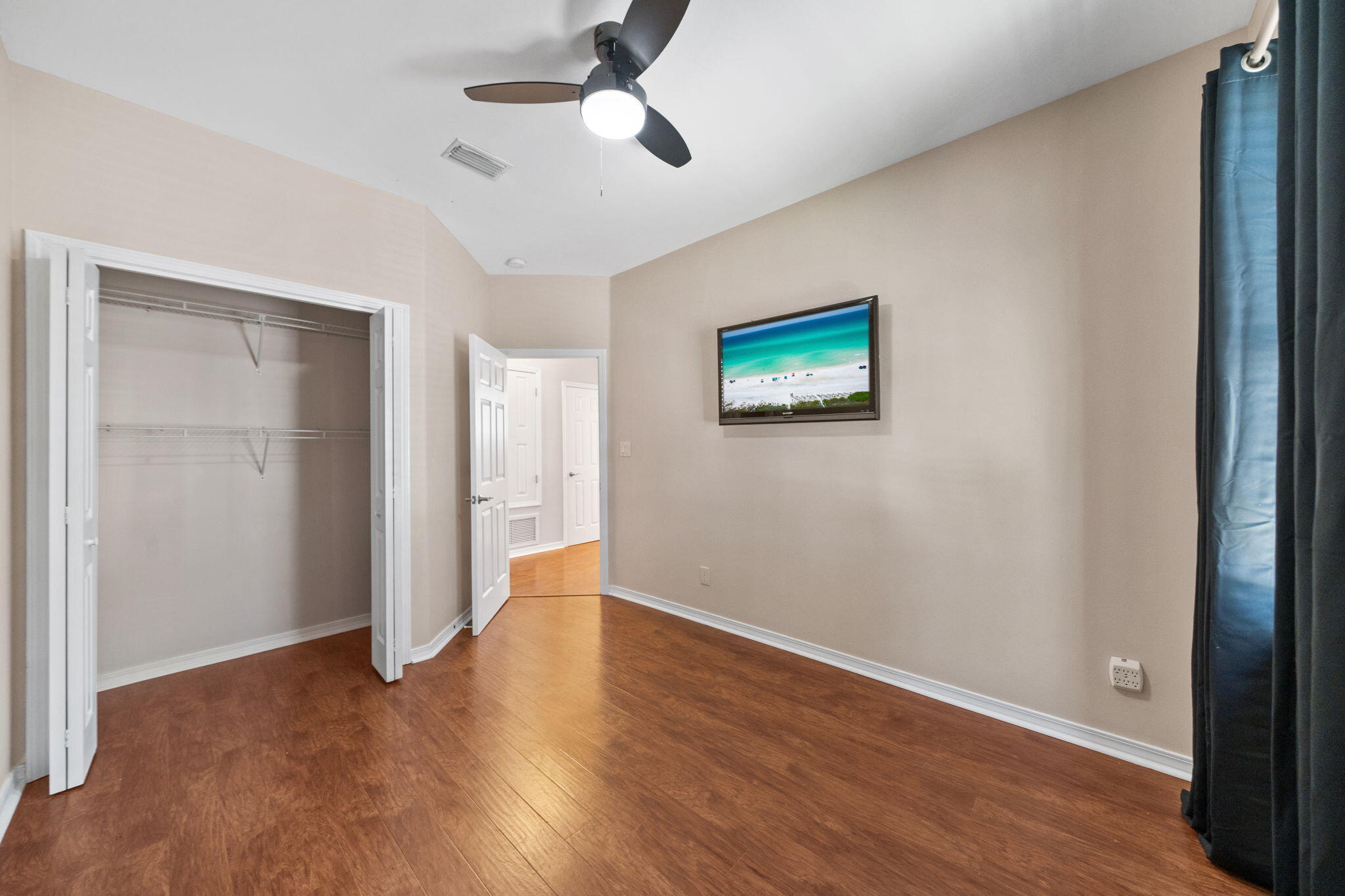 229 Inverrary Drive Destin, FL 32541 - Photo 30 of 35 an empty room with wooden floor and ceiling fan