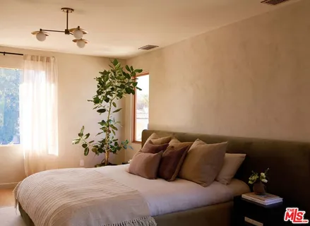 a bedroom with a bed and a potted plant