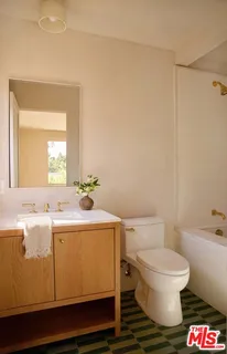 a bathroom with a sink a toilet and a mirror