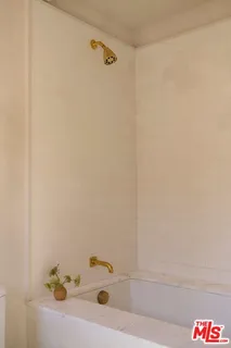 a bath tub sitting next to a white sink and vanity