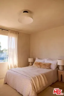 a bedroom with a bed and a night stand