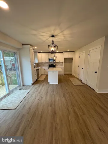 a view of a kitchen with a sink and wooden floor